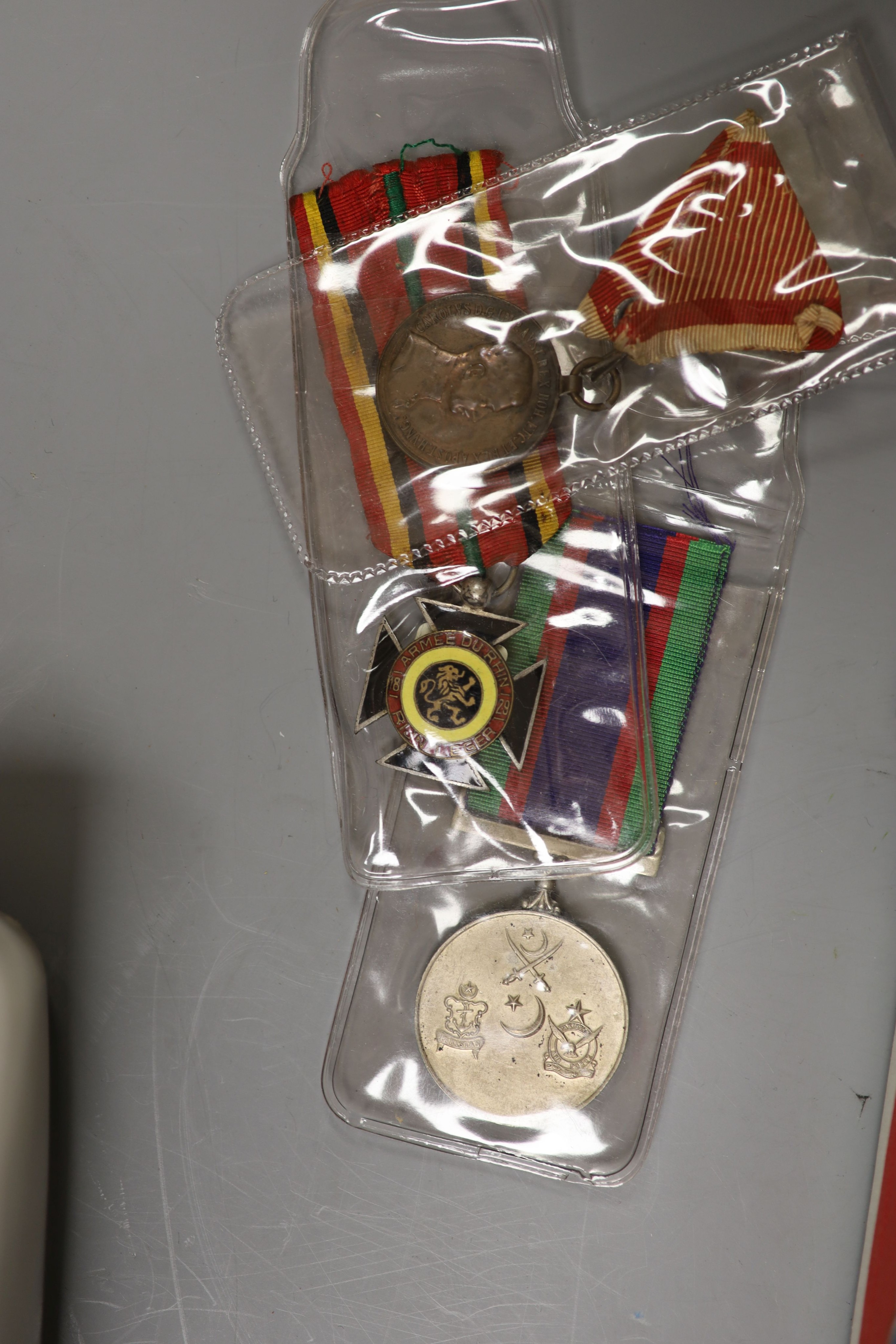 A group of British military cap badges and buttons, various commemorative medals and Pakistan General Service Medals